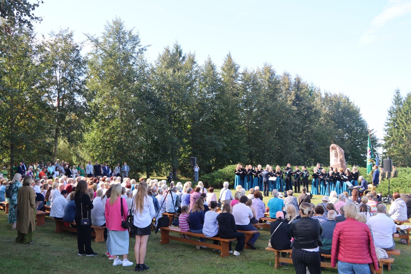 Atceres pasākuma dalībnieki klausās dziedātāju koncertu pie K.Ulmaņa pieminekļa